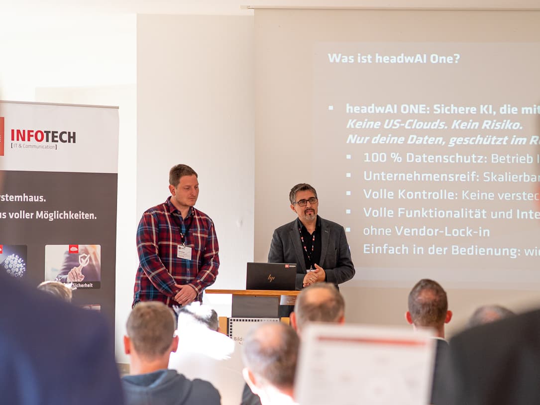 Two presenters beside a slide headed Was ist headwAI One? during the talk on managed AI