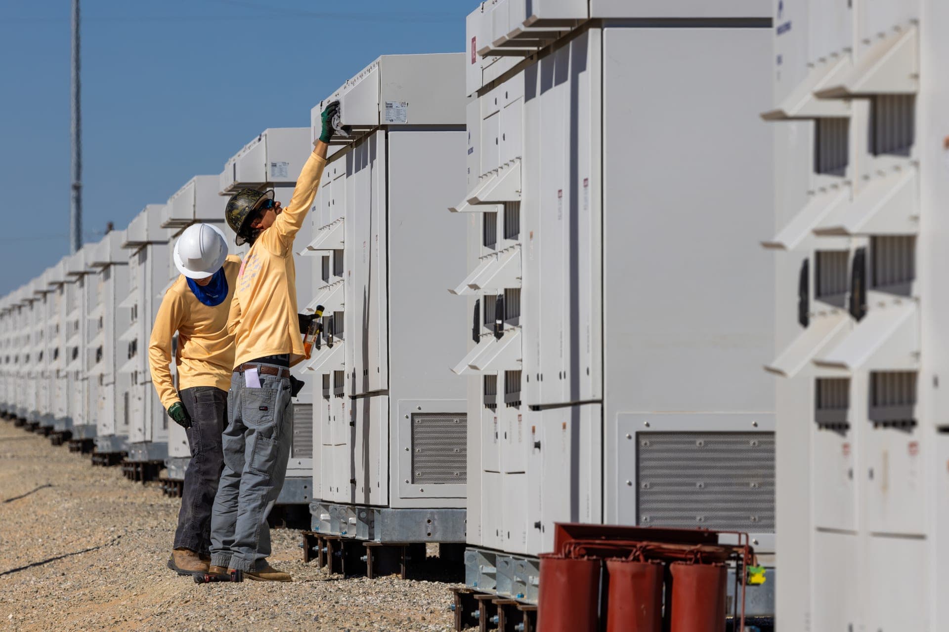 Utility-scale battery-storage deployment alongside a solar farm — representative of the asset class ASE commissions