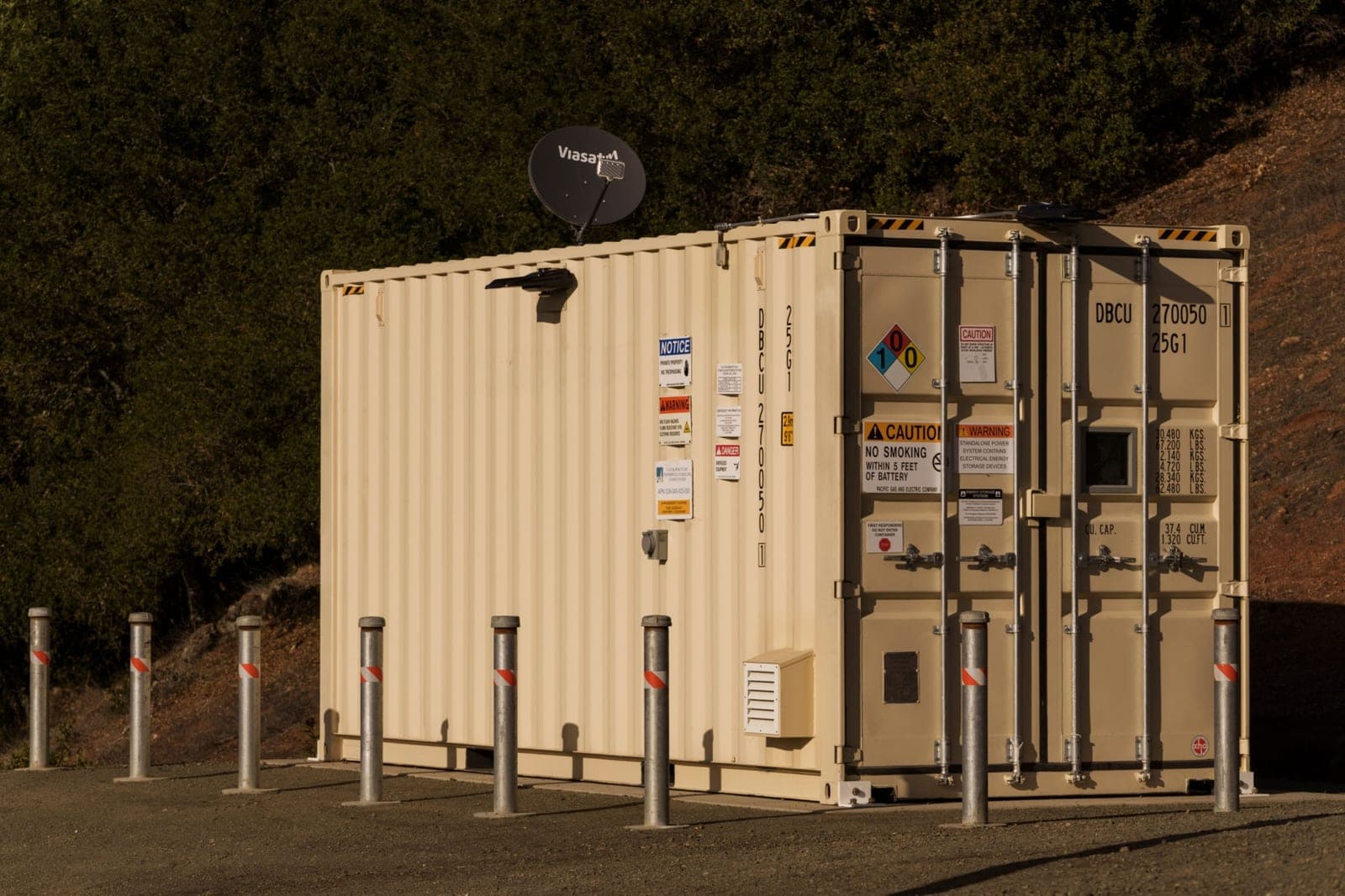 Rows of utility-scale battery-storage cabinets under daylight