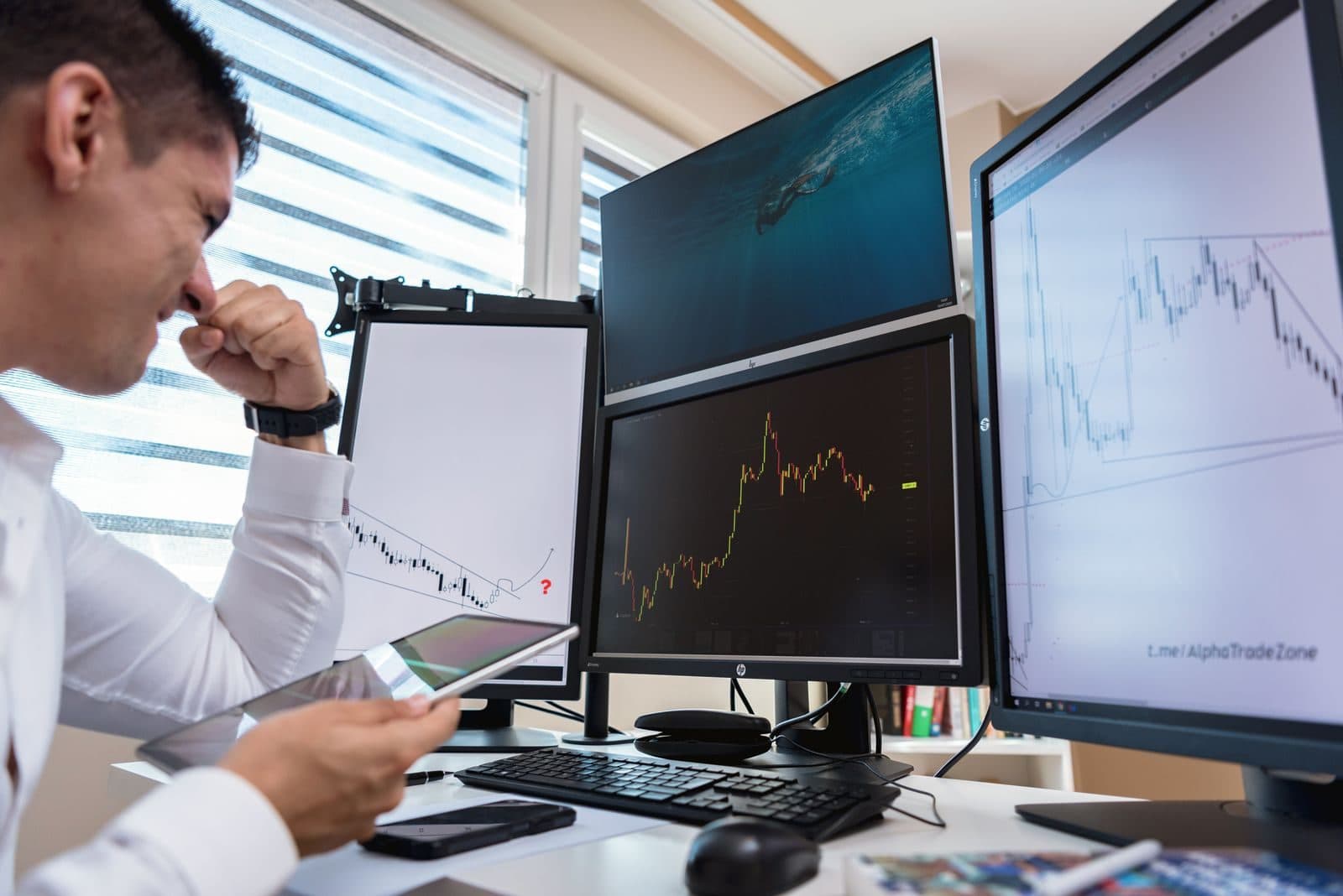 Analyst working across two monitors of performance charts
