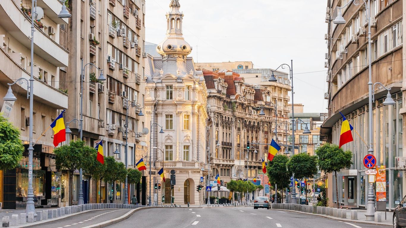 Bucharest boulevard with heritage buildings and Romanian flags
