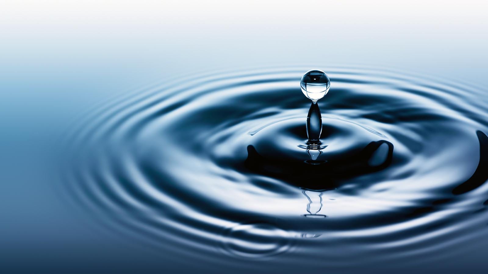 Droplet striking a still lake surface — a single source, disciplined behaviour