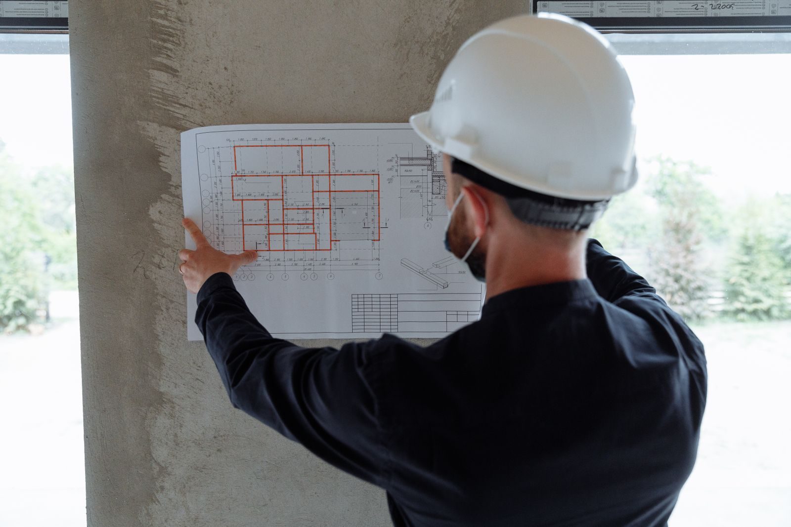 Engineer in a hard hat reviewing plans on site